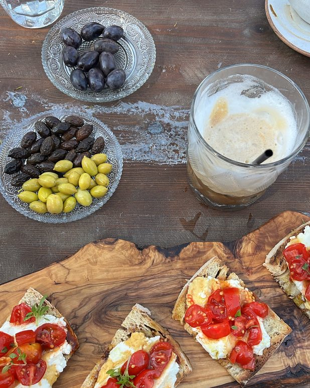 Tomato and ricotta bruschetta with olives and a cold drink