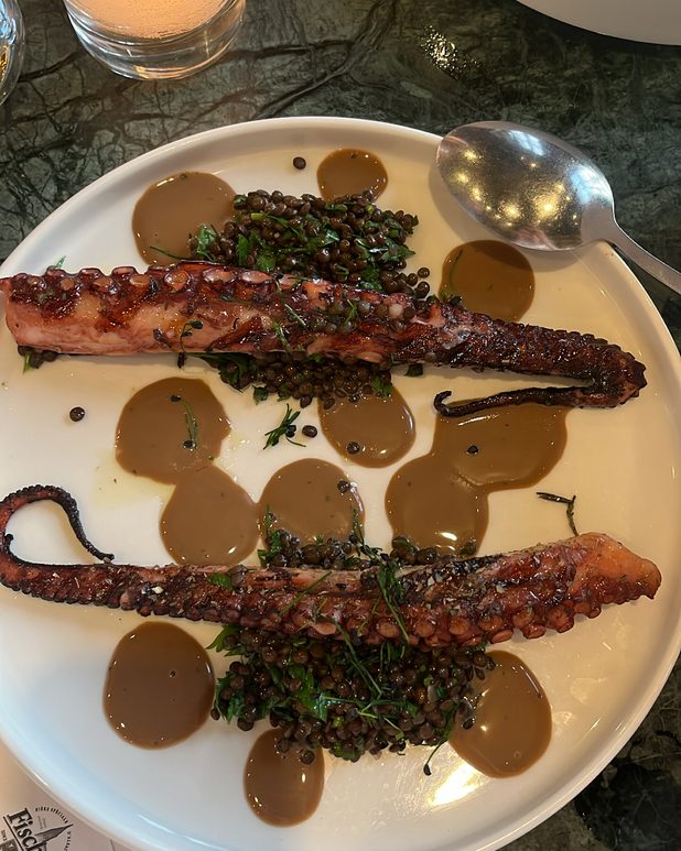 Grilled octopus tentacles with lentils and a scatter of sauce