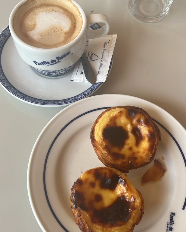 Two pastéis de nata and a cappuccino