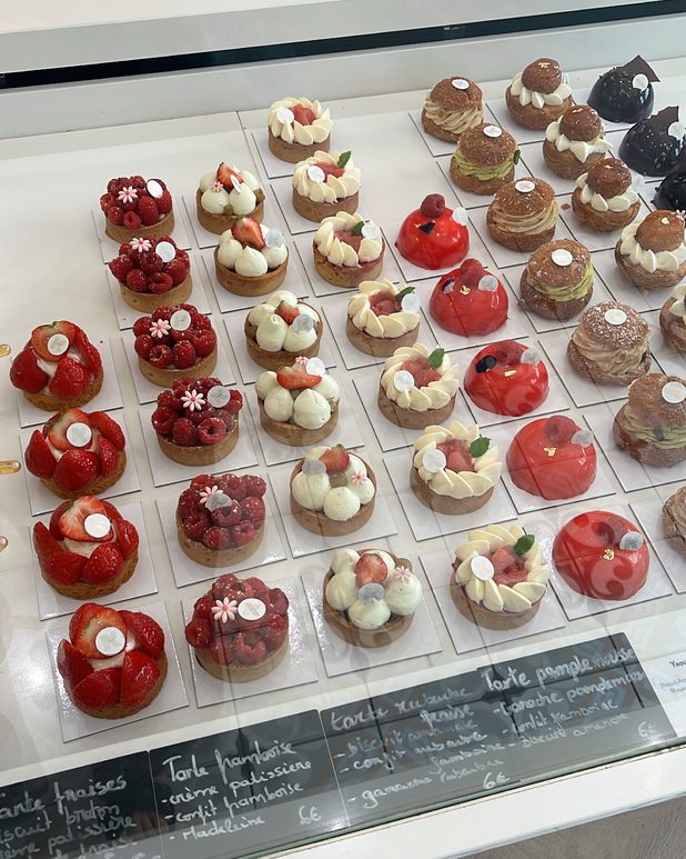 Rows of fruit tartlets in a pâtisserie display case