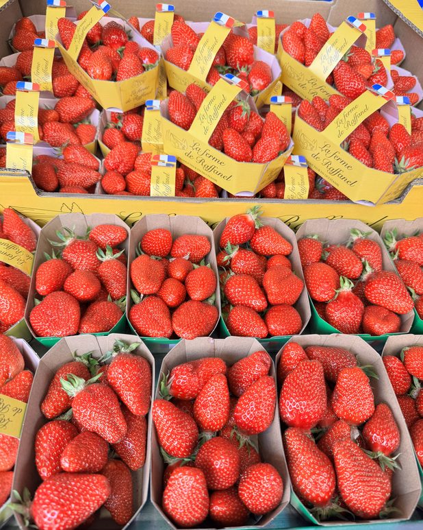 Punnets of strawberries stacked at a market stall